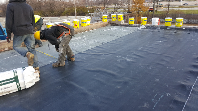 Installing and fully adhering the new .90mil EPDM membrane. 